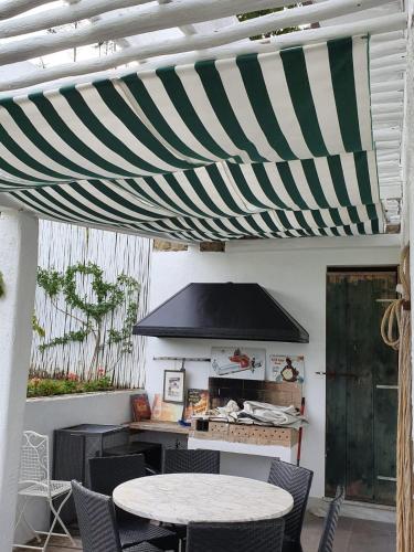 awning over a patio with a table and chairs at Orchidea in Beverino