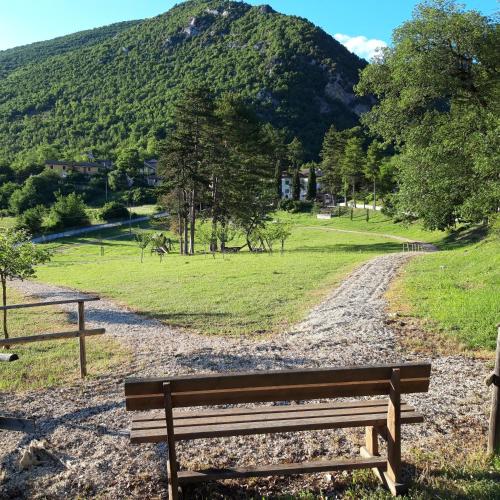 a wooden bench sitting on a gravel road with a mountain at FonteAntica Agriturismo in Norcia