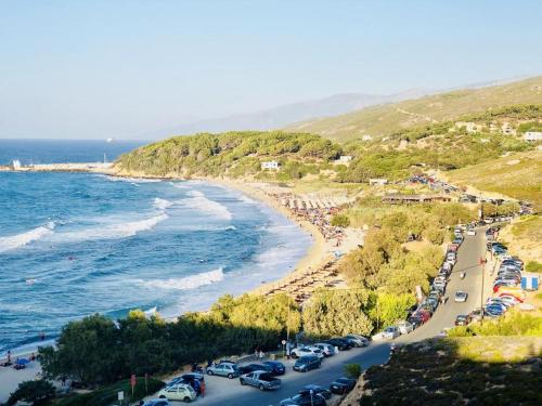 Una playa con muchos coches estacionados junto al agua en Dolihis gi, Poseidon, en Gialiskari