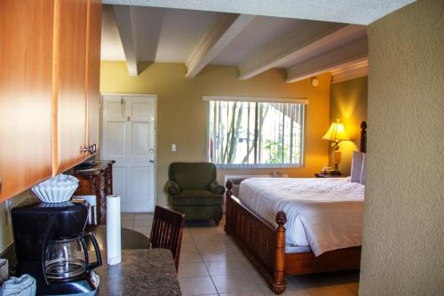 1 dormitorio con 1 cama, 1 silla y 1 mesa en Bayside Inn and Marina en St Pete Beach
