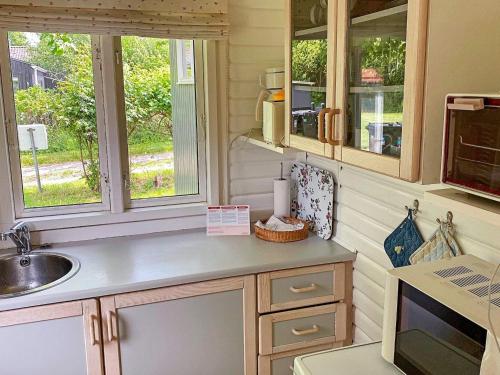 een keuken met een wastafel en 2 ramen bij 4 person holiday home in Stege in Pollerup Kullegård