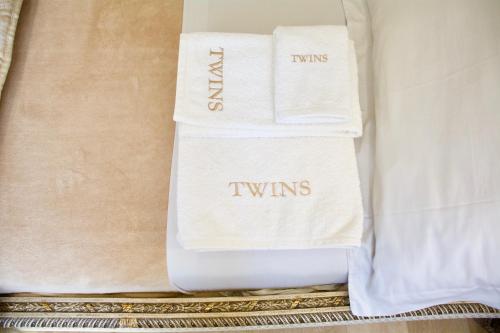 ボルディゲーラにあるTwins Apartmentのベッドの上に座るタオル2枚