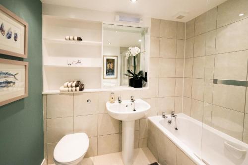 a bathroom with a sink and a toilet and a tub at The Malt Kiln Apartment Edinburgh Old Town 3 Bedroom in Edinburgh