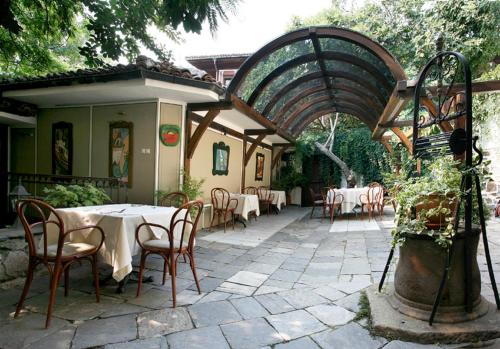 a patio with tables and chairs and an archway at Old Legends Hotel in Plovdiv