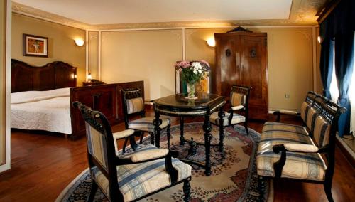 a bedroom with a table and chairs and a bed at Old Legends Hotel in Plovdiv