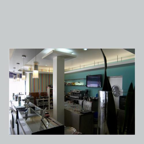 a room with a restaurant with a counter and a kitchen at RESIDENCIAL RITA in Odemira
