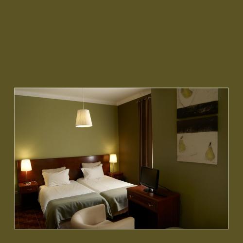 a hotel room with a bed and a television at RESIDENCIAL RITA in Odemira