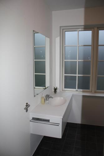 a white bathroom with a sink and a mirror at Skibbild Bed no Breakfast in Herning