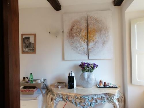 Una habitación con una mesa con un jarrón de flores. en Antico Borgo, en Bagnoregio