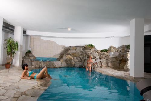 two people in a swimming pool in a water park at Hotel Rainhof in Senales