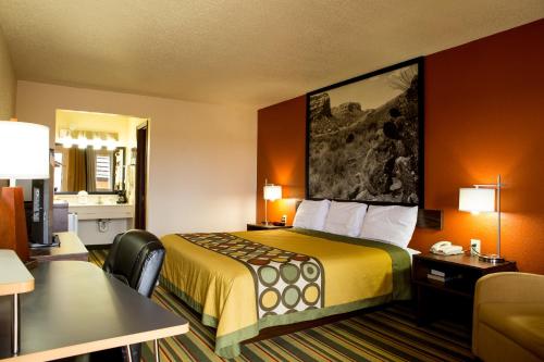 a hotel room with a bed with a yellow bedspread at Super 8 by Wyndham Woodward in Woodward