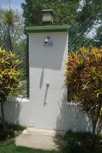 Una pared blanca con una casa de pájaros. en Cozy Cottage Posada Turistica en San Andrés
