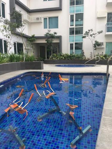 a swimming pool with chairs in the water at Furnished Studio Megaworld 7M in Iloilo City