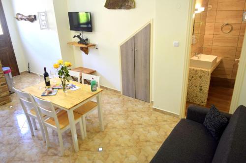 a dining room with a table and chairs and a bathroom at Dourios Ippos Apartments in Frikes