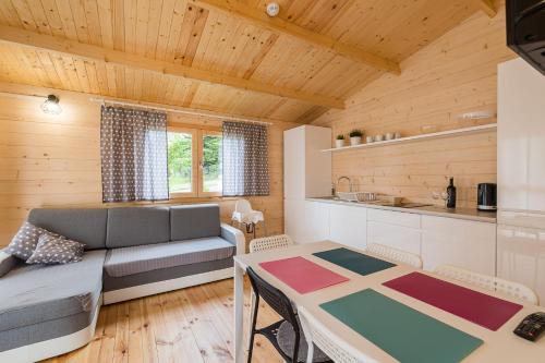 a living room with a couch and a table at Domki z Papieru in Polańczyk