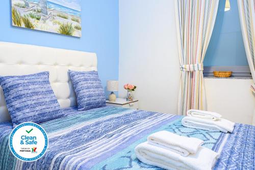 a blue bedroom with a bed with towels on it at Terrace Matosinhos House in Matosinhos