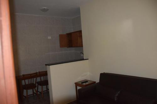 a living room with a couch and a kitchen at Pousada Campos do Jordão in Campos do Jordão