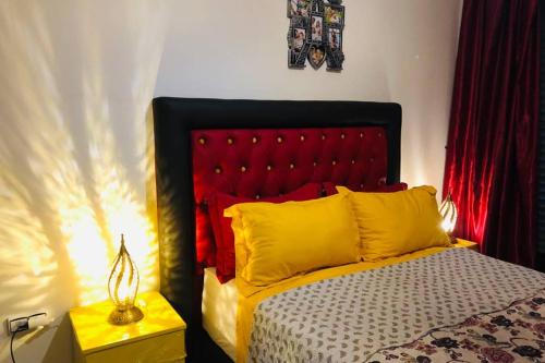 1 dormitorio con 1 cama con cabecero rojo en Pieds dans l'eau, piscine face à la mer - Adan beach - entre Agadir et Taghazout, en Agadir