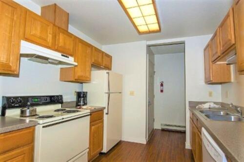 una cucina con mobili in legno e un frigorifero bianco di Twin Rivers By Alderwood Colorado Management a Fraser