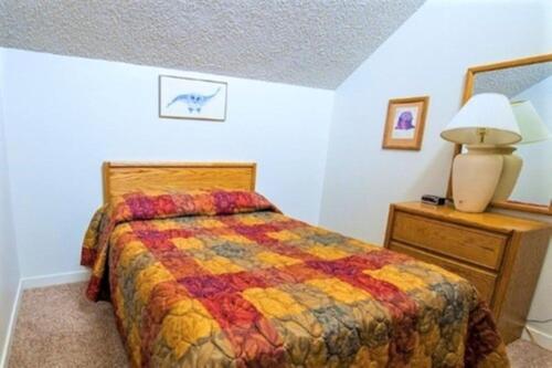 a bedroom with a bed and a lamp on a dresser at Twin Rivers By Alderwood Colorado Management in Fraser