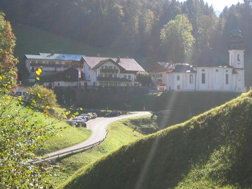 a village with cars parked on a winding road at Gasthof Und Hotel Maria Gern in Berchtesgaden