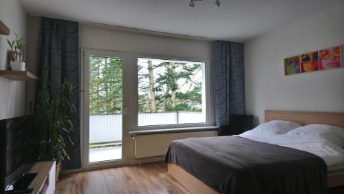 a bedroom with a bed and two large windows at Melia in Hamm