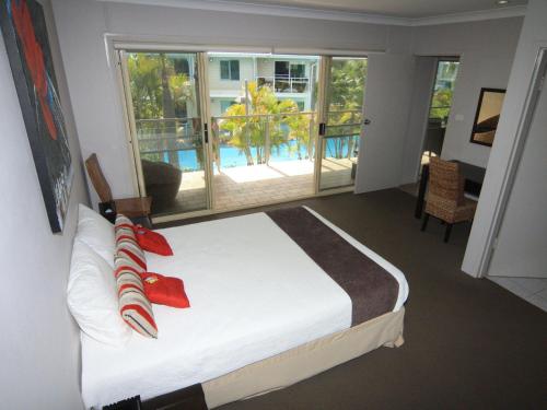 a bedroom with a bed and a view of a pool at Oaks Pacific Blue 339 Huge Resort Lagoon Pool in Salamander Bay