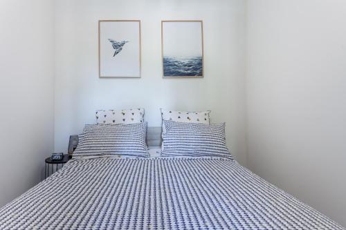 a bed with two blue and white striped pillows at Kelys Centre T2 Confort Moderne in Boulogne-sur-Mer