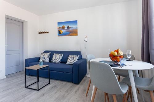 un salon avec un canapé bleu et une table dans l'établissement Kelys Centre T2 Confort Moderne, à Boulogne-sur-Mer