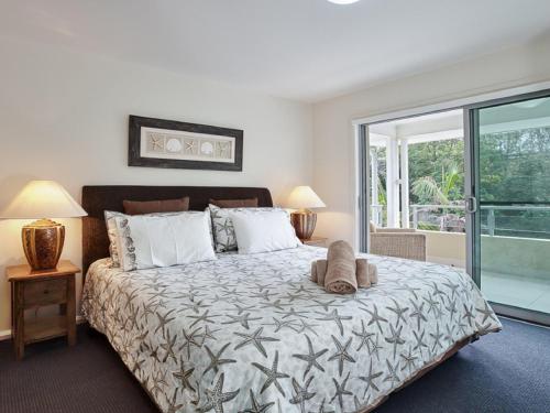 a bedroom with a large bed and a window at Oaks Pacific Blue 516 private pool aircon WI-FI in Salamander Bay