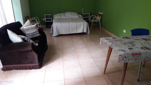 a living room with a table and a bed at Complejo Berazategui in Villa D. Sobral