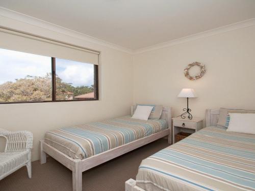 a bedroom with two beds and a window at Promenade 11 air conditioned unit with beautiful water views in Shoal Bay