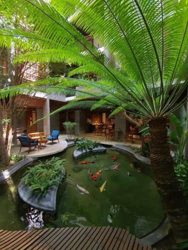 a koi pond in a hotel with a palm tree at Minh Boutique in Da Nang