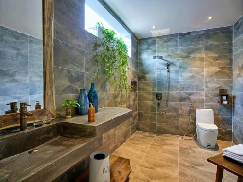 a bathroom with a sink and a shower and a toilet at M Village Phu Quoc in Phu Quoc