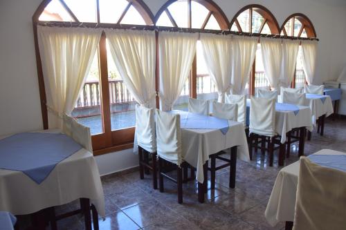 a row of tables in a restaurant with windows at Pousada Campos do Jordão in Campos do Jordão