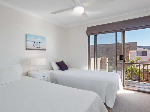 biała sypialnia z 2 łóżkami i oknem w obiekcie Skyline, 6,12 Thurlow Avenue - Unit with stunning views, Aircon and Wi-fi w mieście Nelson Bay