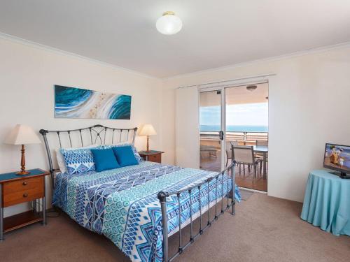 Schlafzimmer mit einem Bett und Meerblick in der Unterkunft The Clippers 3 fabulous waterfront unit in Salamander Bay