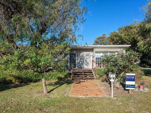 a house with a sign in front of it at The Croft Cosy Beach House with Aircon and only 270m to the Beach in Fingal Bay