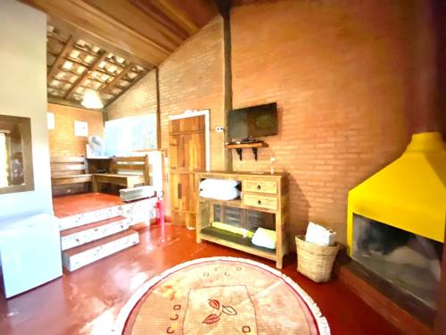 a room with a living room with a fireplace at Pousada Recanto da Siriema in Monte Alegre do Sul