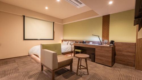 a room with a bed and a desk with a chair at Galois Hotel Shinokubo in Tokyo