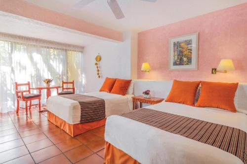 a hotel room with two beds and a table at Hotel Racquet Cuernavaca in Cuernavaca