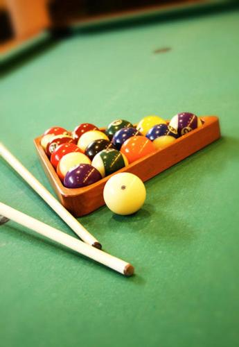 a cue ball and cue stick on a pool table at Hotel Maxim in Svätý Jur
