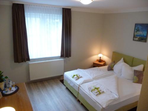 um quarto com uma cama branca e uma janela em Hotel Mecklenburger Mühle Garni em Wismar