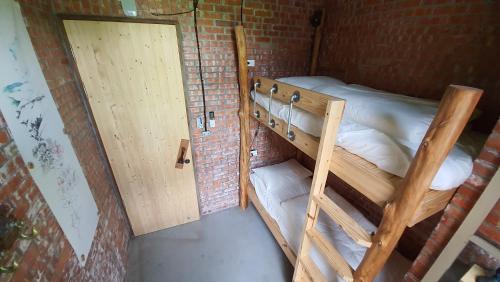 a room with two bunk beds in a brick wall at 缽割貓點點 青旅 DianDian hostel in Puli