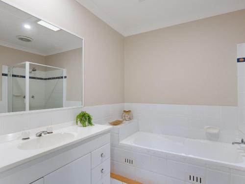 a white bathroom with two sinks and a tub at Walk on Birubi 1 Pet Friendly WI-FI Boat Parking and Water Views in Anna Bay