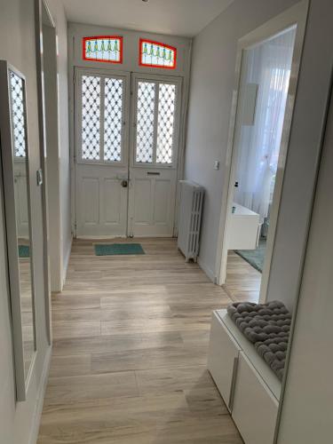 - un couloir d'une maison avec une porte et des fenêtres dans l'établissement Relais Vacances à la Mer 2, à Berck-sur-Mer