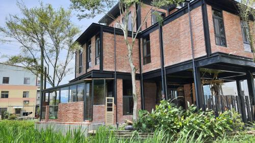 a brick building with glass windows on the side of it at 缽割貓點點 青旅 DianDian hostel in Puli