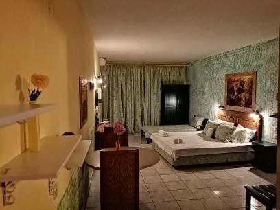 una camera d'albergo con letto e soggiorno di Nikos Victoria a Città di Skiathos