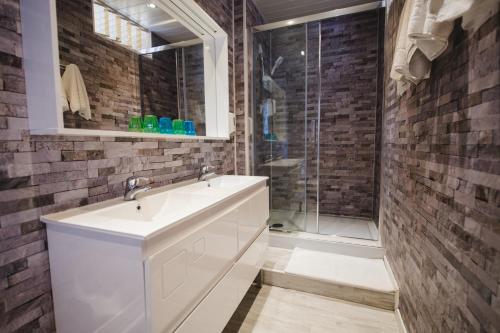 een badkamer met een witte wastafel en een douche bij Hotel Belle Vue in Souillac