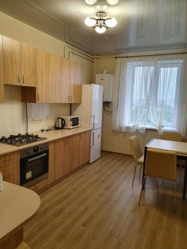 una cucina con armadi in legno e frigorifero bianco di Апартаменти Чорновола a Luc'k